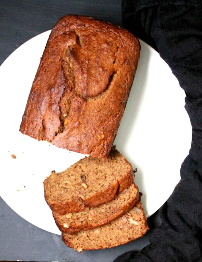 Top shot of sliced vegan banana bread with three slices on a white plate