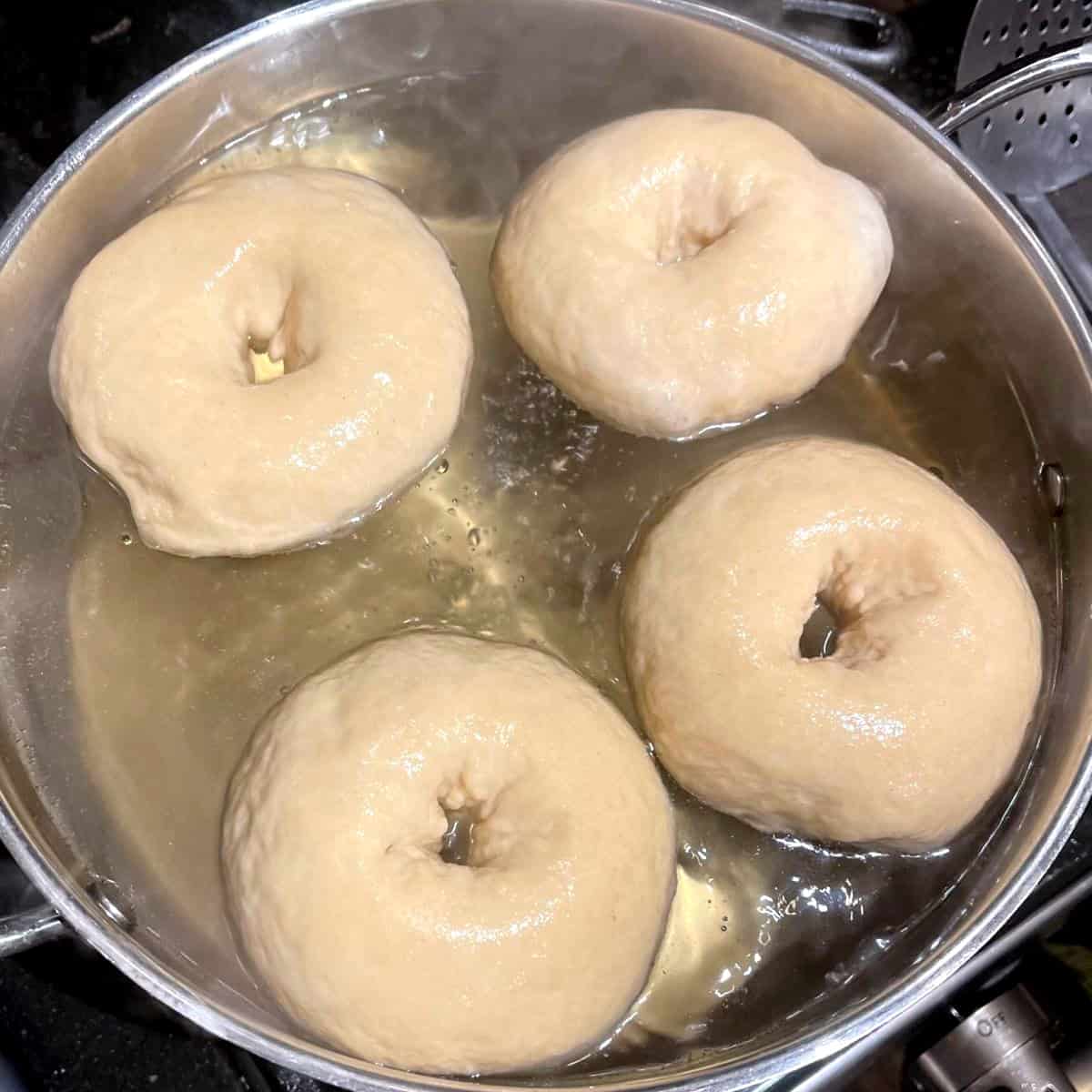 Four bagels in water bath.