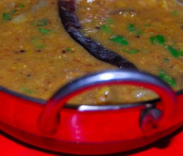 Brinjal rasavangi in a steel kadhai with cilantro garnish