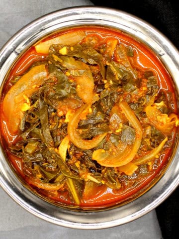 Kashmiri collard greens or haak in traditional copper and steel bowl.