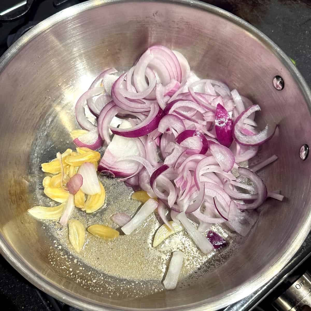 Onions and garlic added to asafetida in pan.