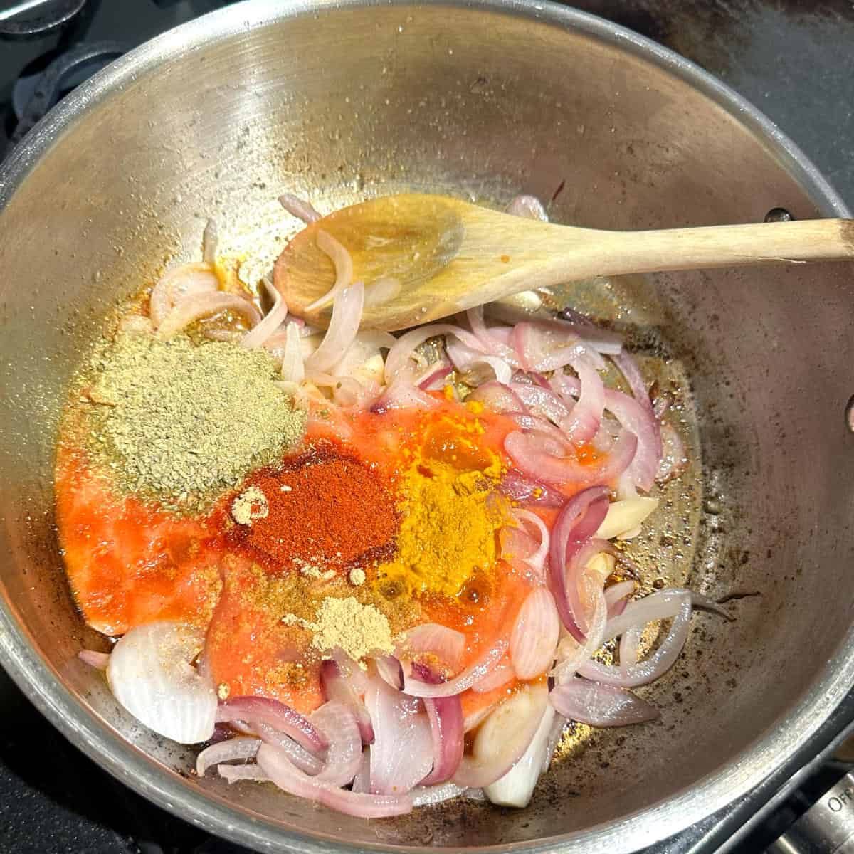 Spices added to pan with onions and tomatoes.