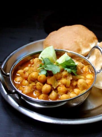 Chole Bhatura or Chana Bhatura is a North Indian dish to die for. A spicy, traditional chana masala is served with a puffy, flaky bread called a Bhatura. You might be lucky enough to find this specialty, usually served at roadside eateries called dhabas in India, at an Indian restaurant. The chana masala is gluten-free. #vegan #soyfree #nutfree #glutenfree #dinner #indian HolyCowVegan.net