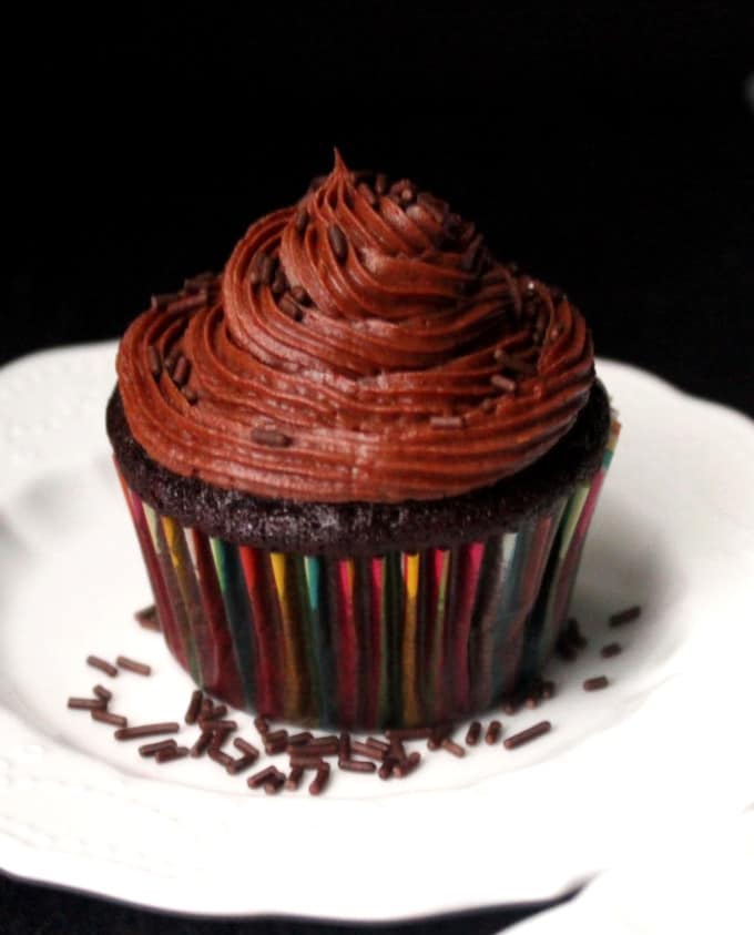 Vegan Chocolate Cupcake on a white plate with chocolate buttercream and chocolate sprinkles