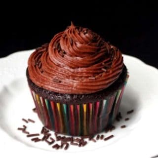 Vegan Chocolate Cupcake with chocolate buttercream and chocolate sprinkles on a decorative white plate