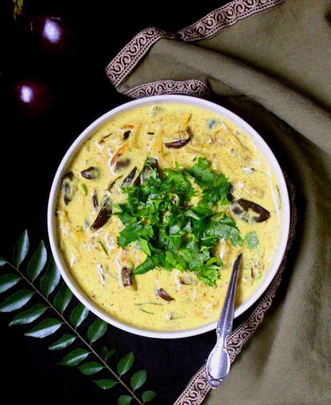 A top shot of a large bowl of creamy Sri Lankan Eggplant Curry with cilantro and turmeric and coconut milk