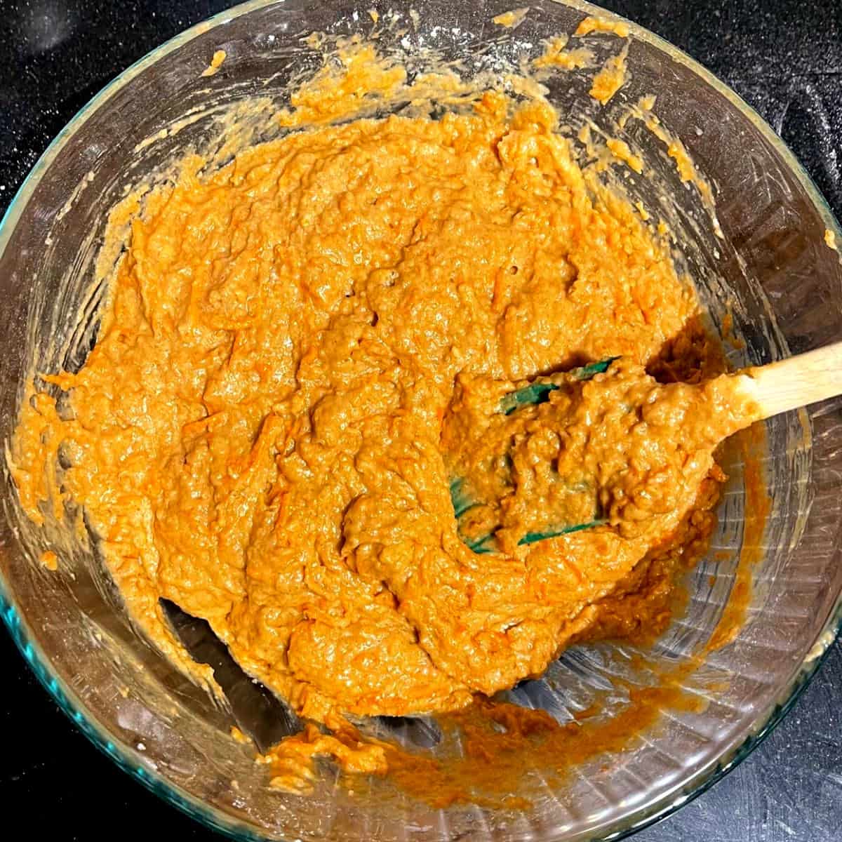Vegan carrot cake batter in bowl with spatula.