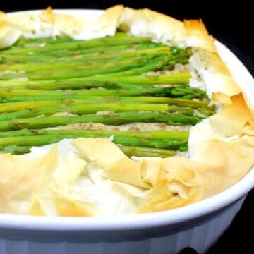Vegan asparagus potato tart in white baking dish.