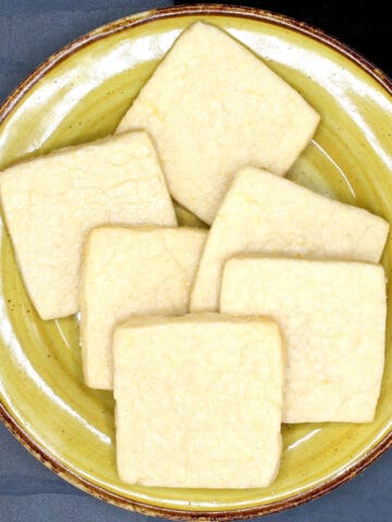 Vegan lemon shortbread cookies on yellow plate.
