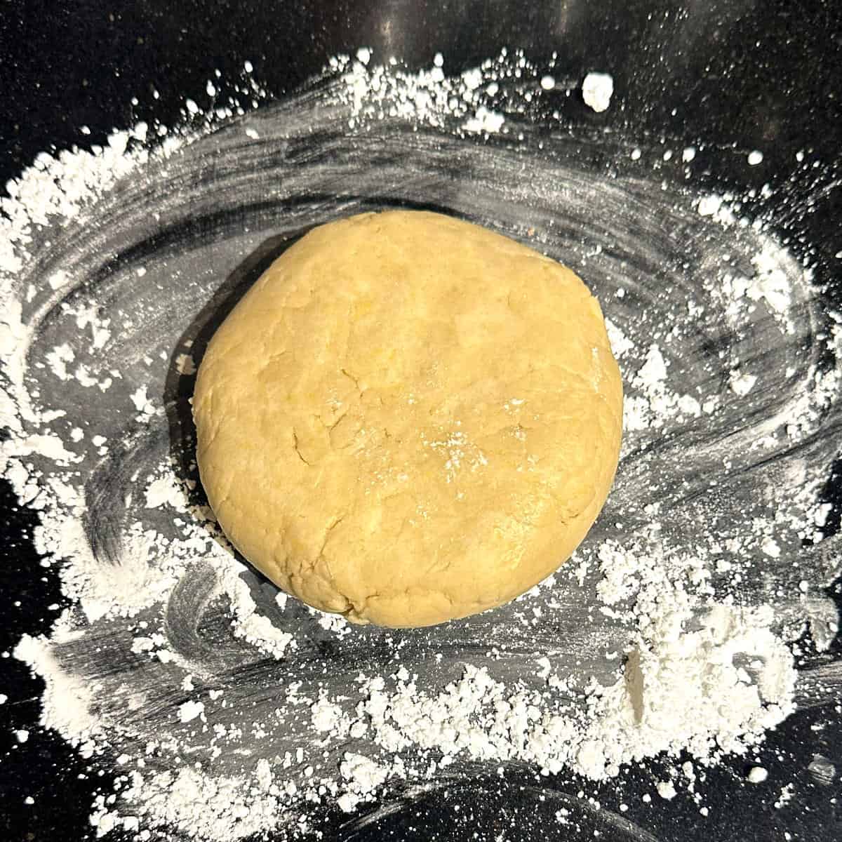 Dough for vegan lemon shortbread cookies formed into a disc.