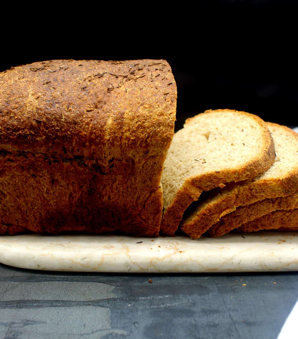 Rye bread, sliced, on marble board.