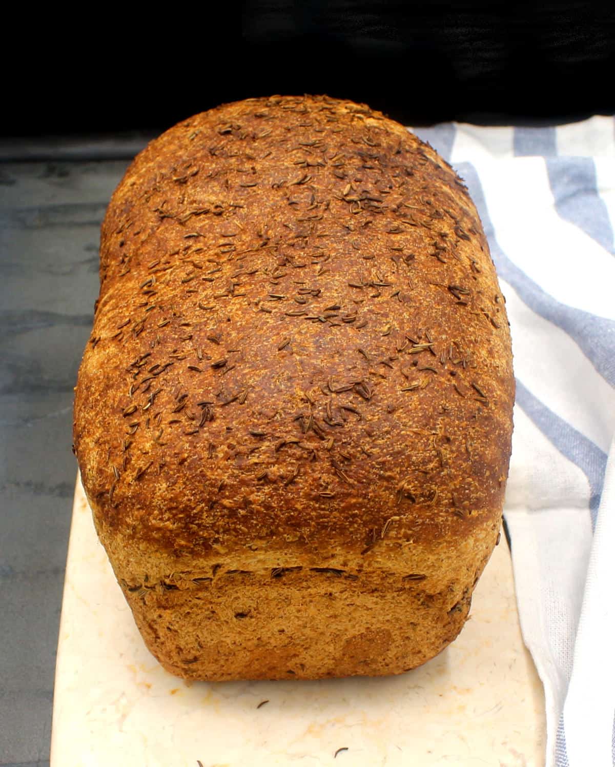 Baked rye bread loaf on marble board.