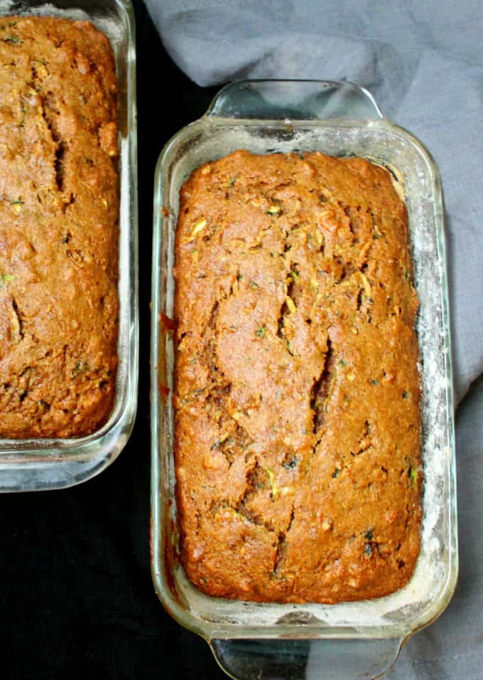 Photo of two loaves of vegan zucchini bread in glass loaf pans.