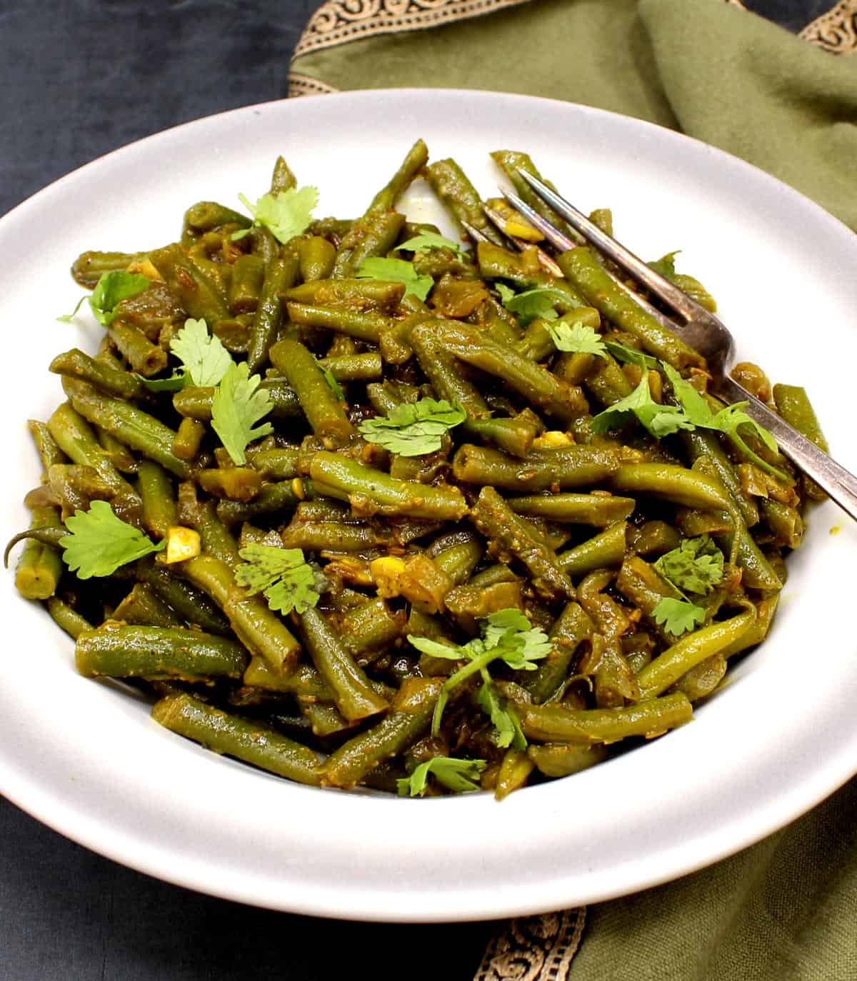 Trinidadian green beans in bowl with cilantro garnish.