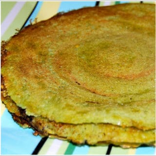 Moong dal dosa on striped plate.