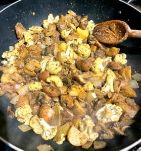 Mushrooms and onions cooking in wok.