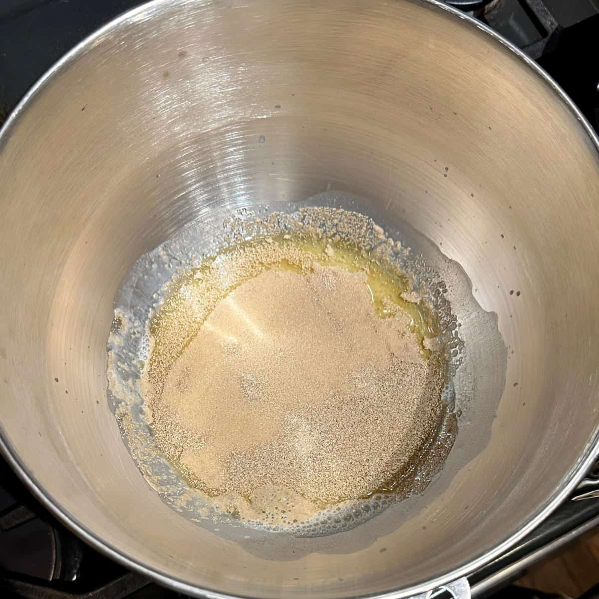 Yeast, water, milk and sugar in stand mixer bowl.