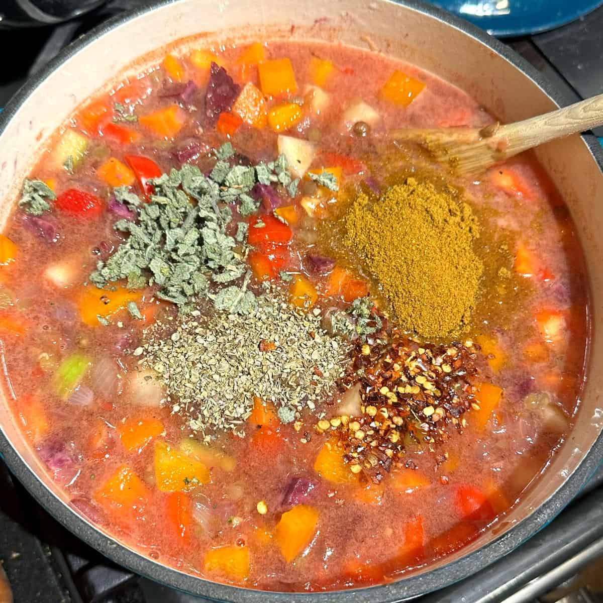 Spices and herbs added to stew in Dutch oven.