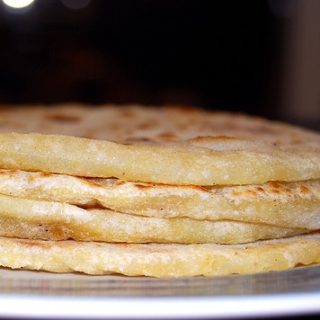 Puran polis stacked on a white plate.