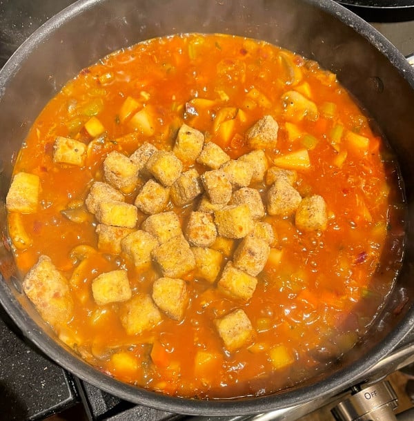Tempeh cubes added to stew