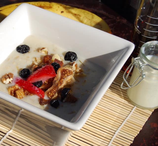 Photo of a bowl of oatmeal with fruits and nuts.