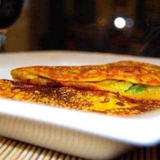 Two besan chilla or chickpea flour omelets in white plate.