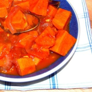 Spicy vegan sweet potatoes in a blue bowl.