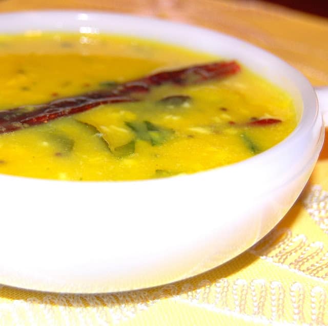 A bowl of dalitoy, a simple western Indian dal, with a red chili pepper.