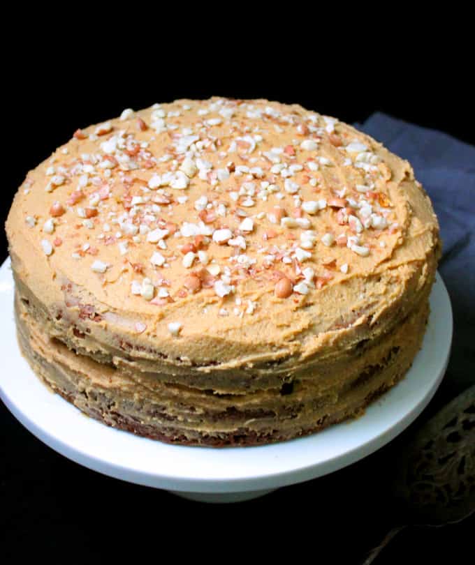 Vegan Banana cake with peanut butter frosting on cake stand.