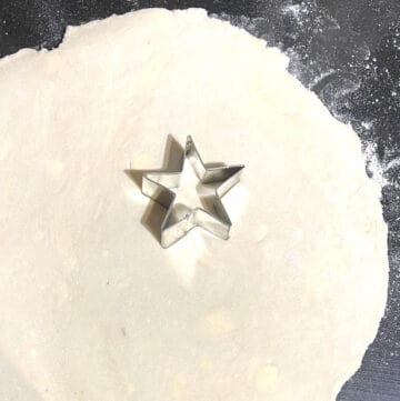 Star cookie cutter on rolled out pie dough.