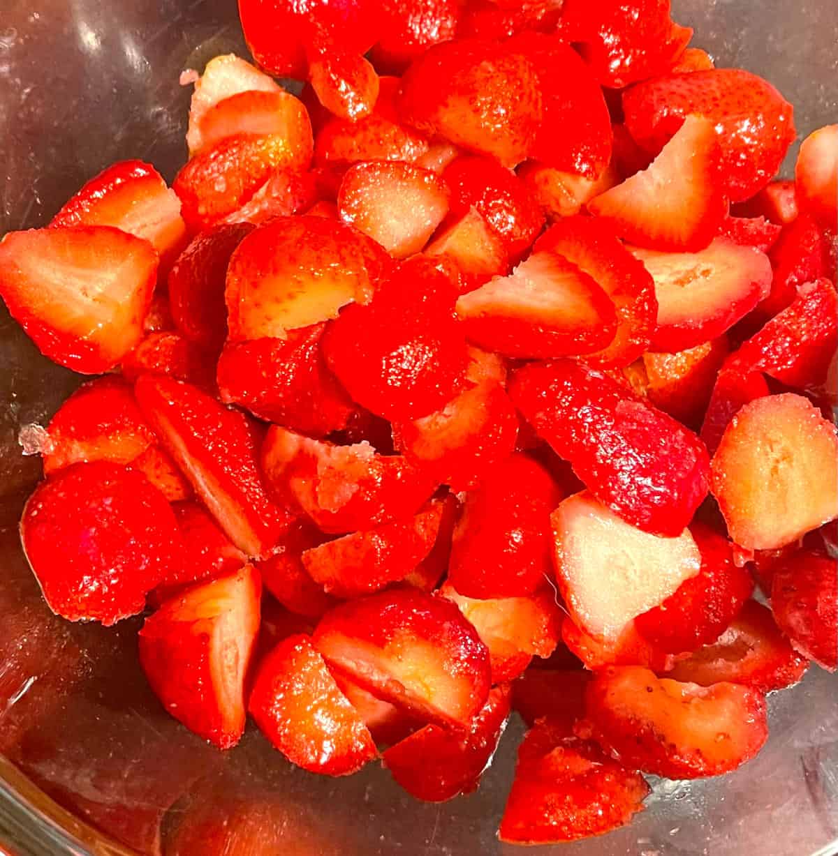 Strawberries halved for pie filling.