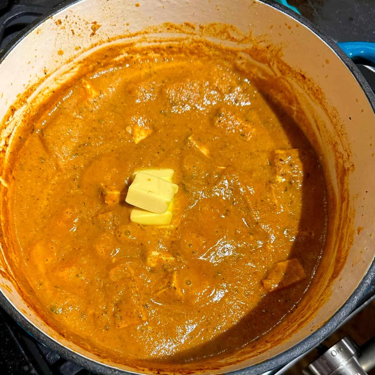 Butter added to makhani in pot.