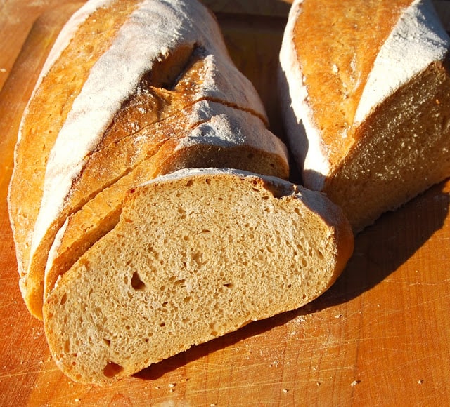 Sliced whole wheat sourdough baguettes with crumb showing.