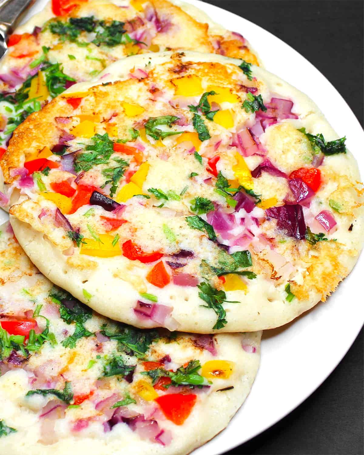 Close up view of uttapam in white plate.