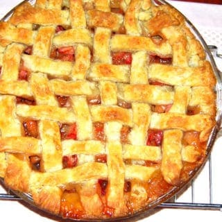 Vegan rhubarb pie with lattice top on wire rack.
