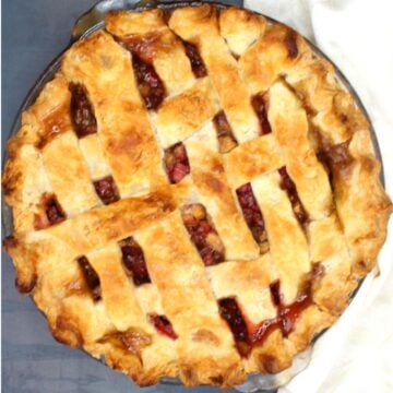 Vegan rhubarb pie with lattice top in pie plate.