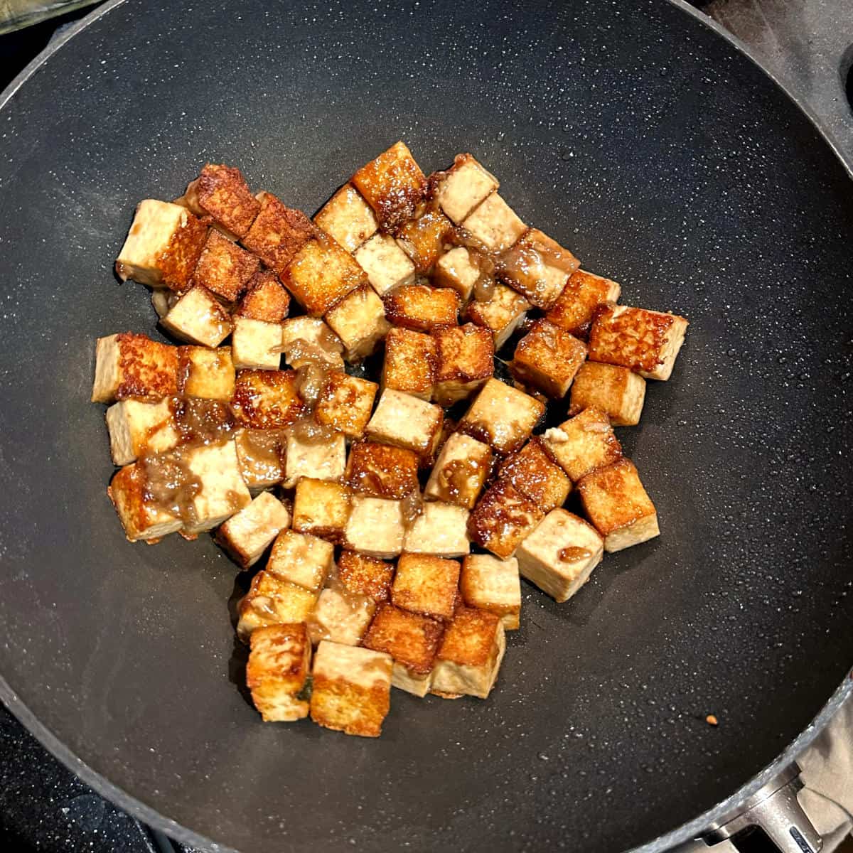 Tofu fried in wok for chilli tofu.