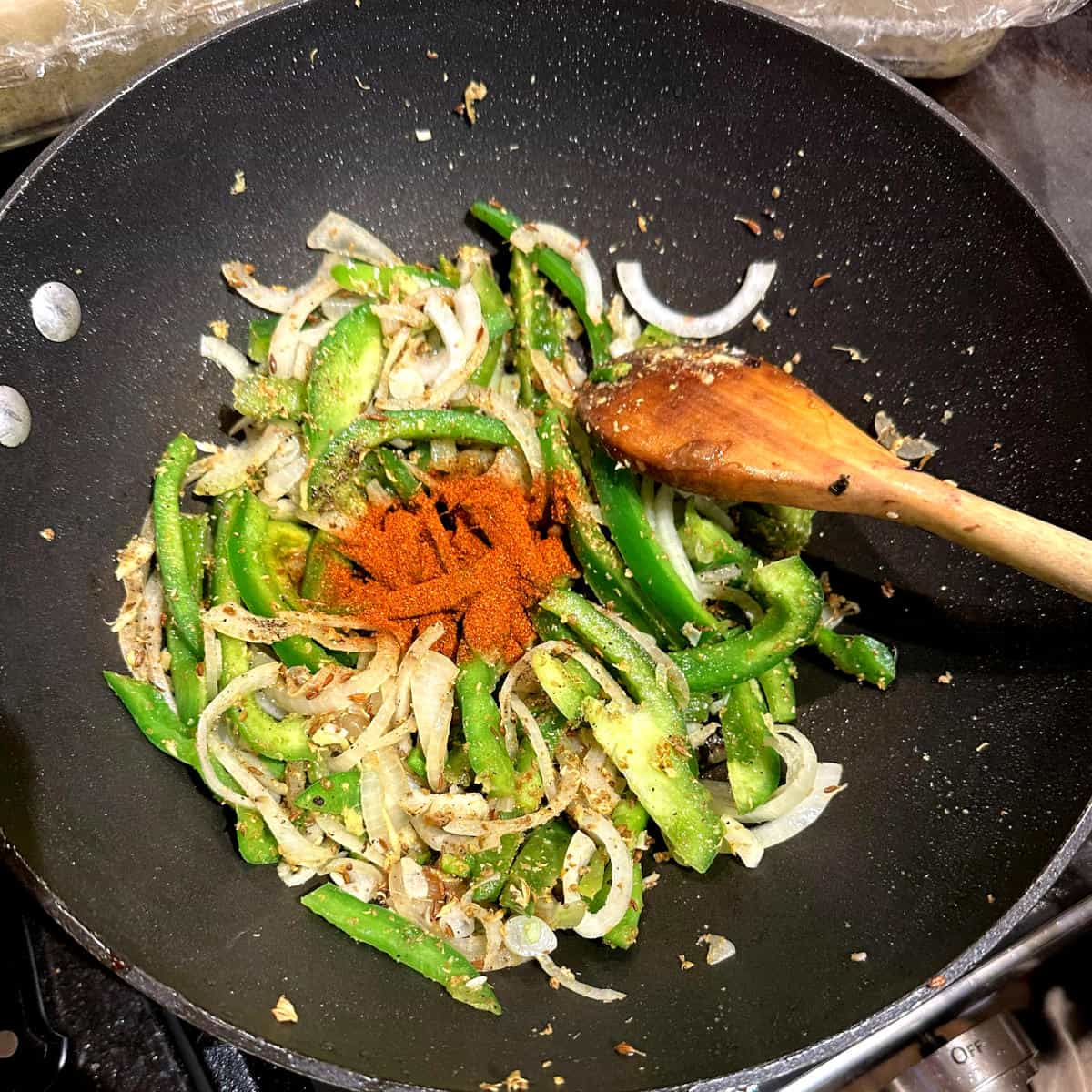 Vegetables and spices added to wok for chilli tofu.