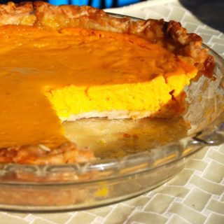Sliced mango pie in glass pie plate.