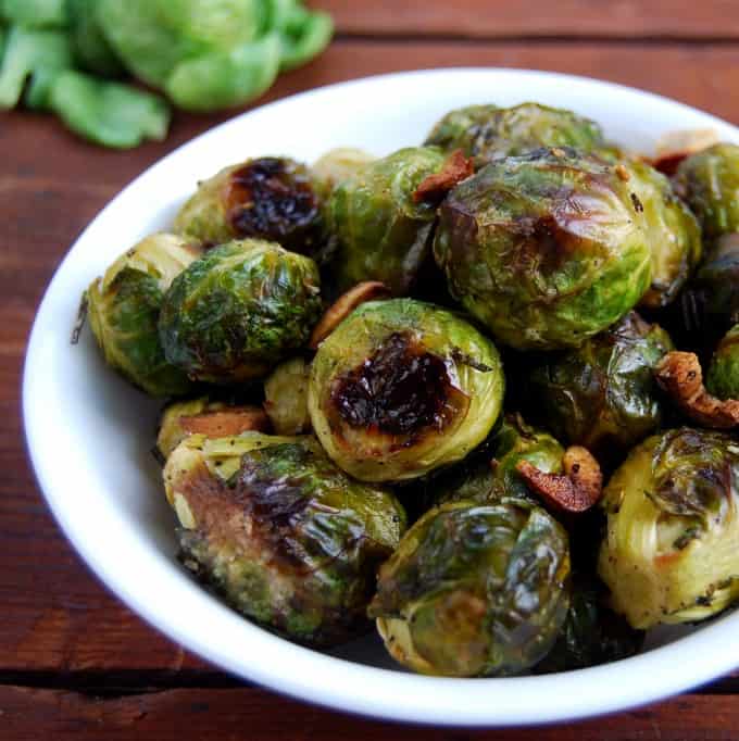 Close-up of roasted Brussels sprouts in a white bowl.