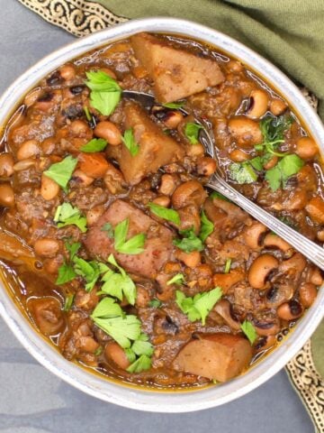 Image of black-eyed peas in bowl with spoon and parsley garnish.
