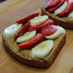 Place sliced bananas and strawberries on toast.