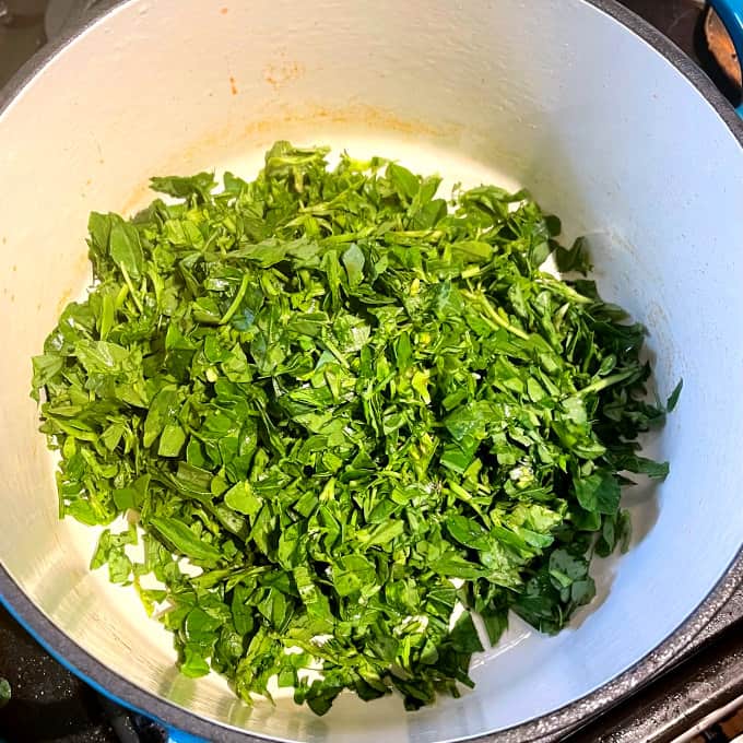 Methi leaves added to saucepan.