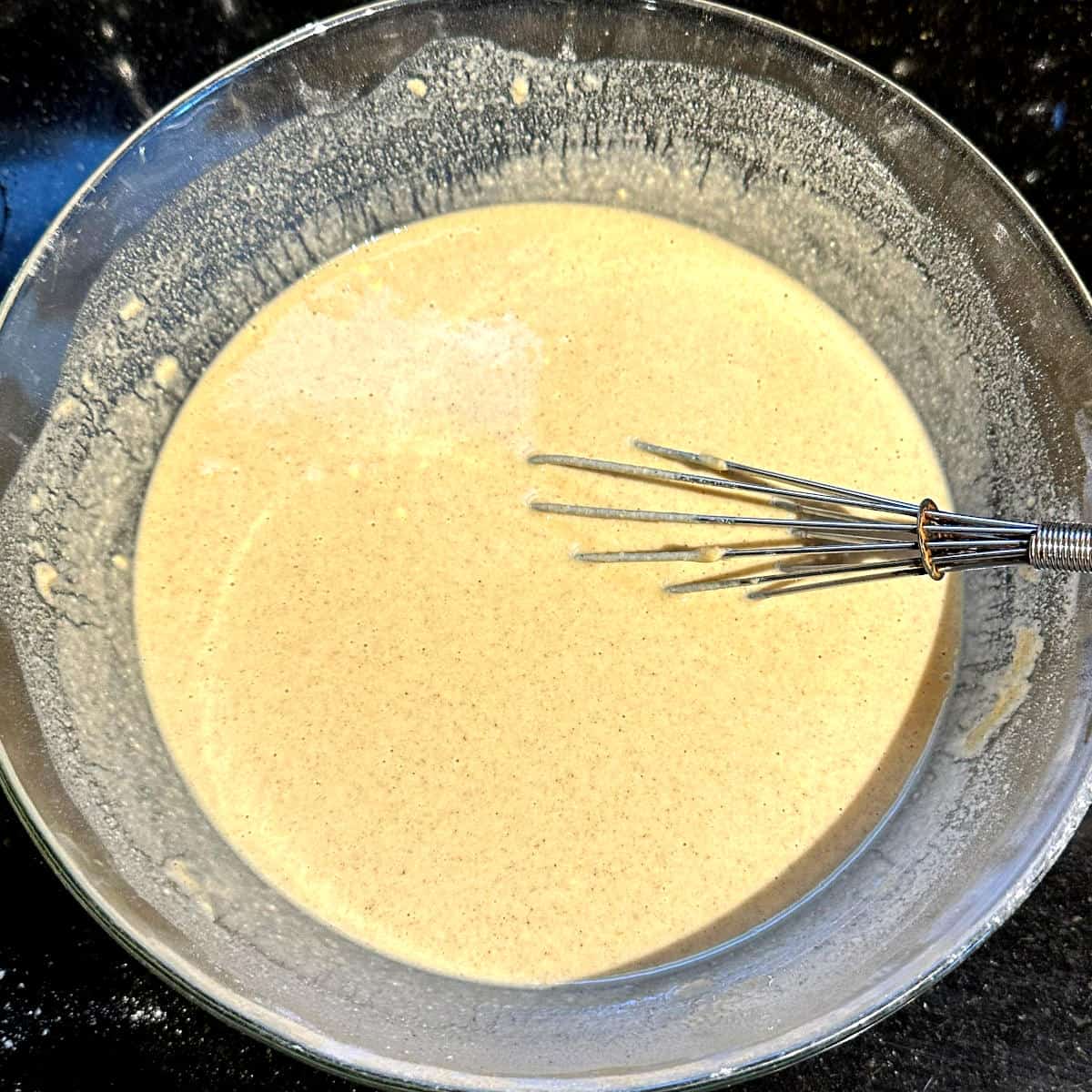 Instant dosa batter in bowl with whisk.