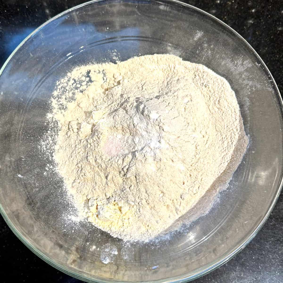 Wheat flour and chickpea flour in bowl with baking soda and salt.