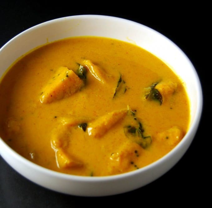 Photo of Mango Curry in a white ceramic bowl with chunks of mango in an orange sauce.