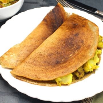 Instant masala dosa with potato stuffing in white plate.