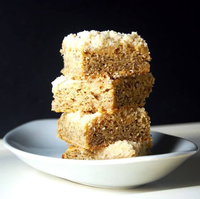 A stack of vegan Banana Chia Cake squares on a gray plate.