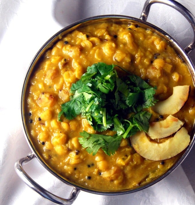 Bengali cholar dal in a steel bowl with coconut and cilantro