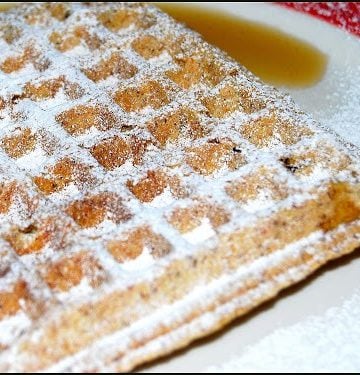 Wholegrain waffle on plate with maple syrup.